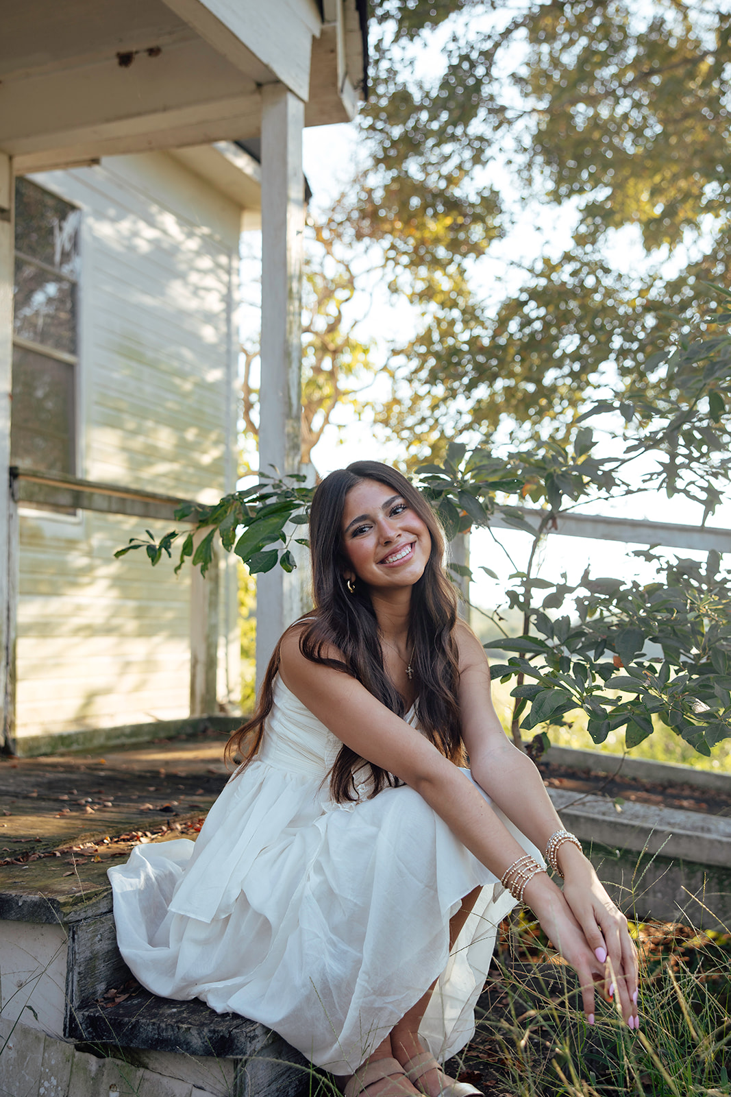 high school senior poses in a Texas field during her senior photo session with Kennedi Cooper Photography