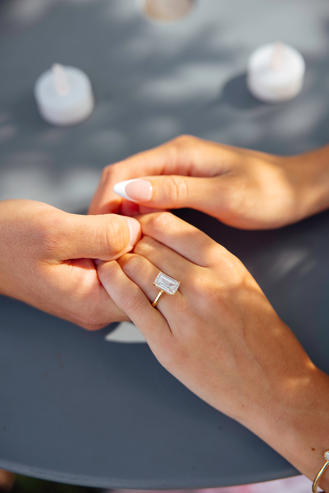 couple sit at a table together and hold hands